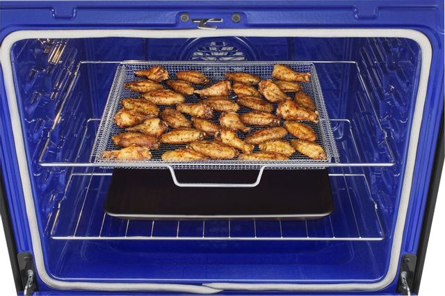 Inside of oven with air fry tray filled with wings. 