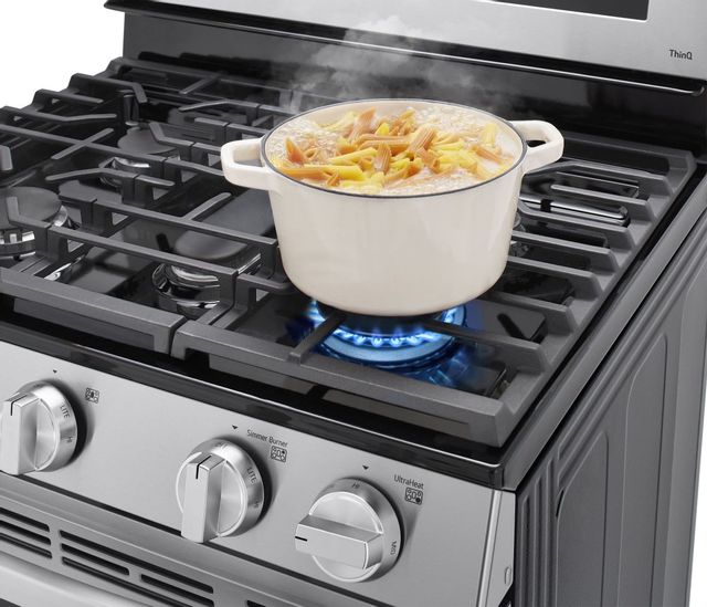 Pot of pasta being boiled over a gas stove top. 