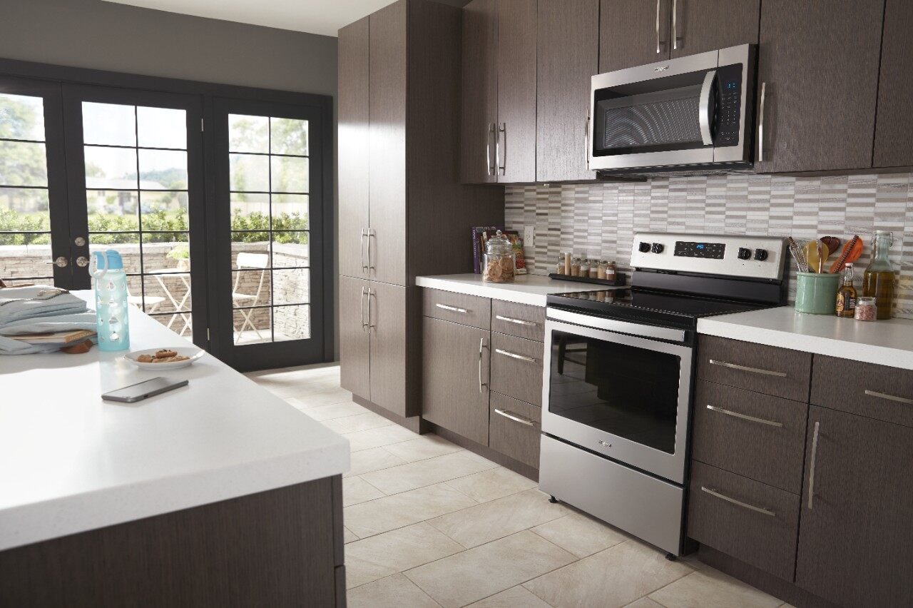 whirlpool over the range microwave and electric range in modern wood kitchen