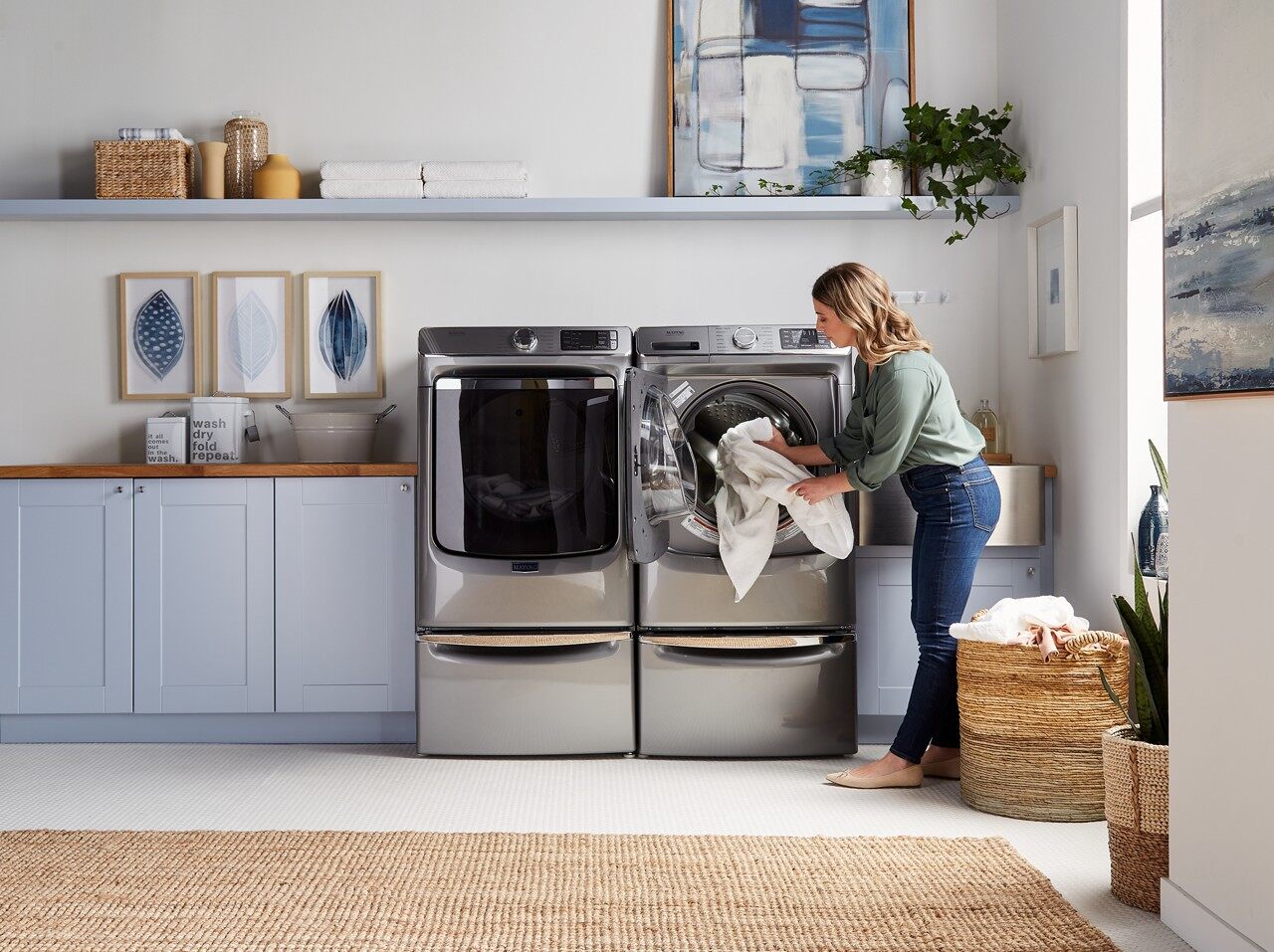 Young woman removing bedding from a Maytag dryer 