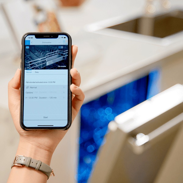 Woman using Home Connect app on Thermador Sapphire dishwasher