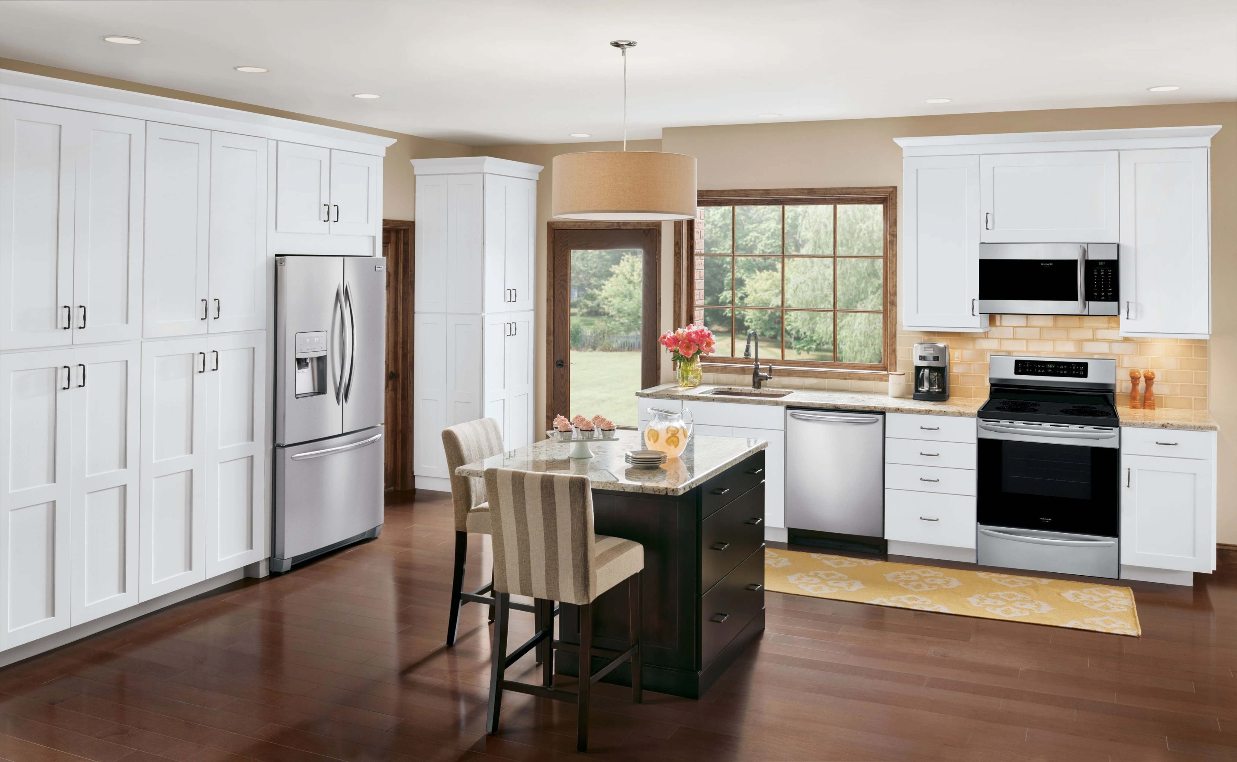 Frigidaire FGHD2368TF French door refrigerator installed in a sunny kitchen with a Frigidaire suite