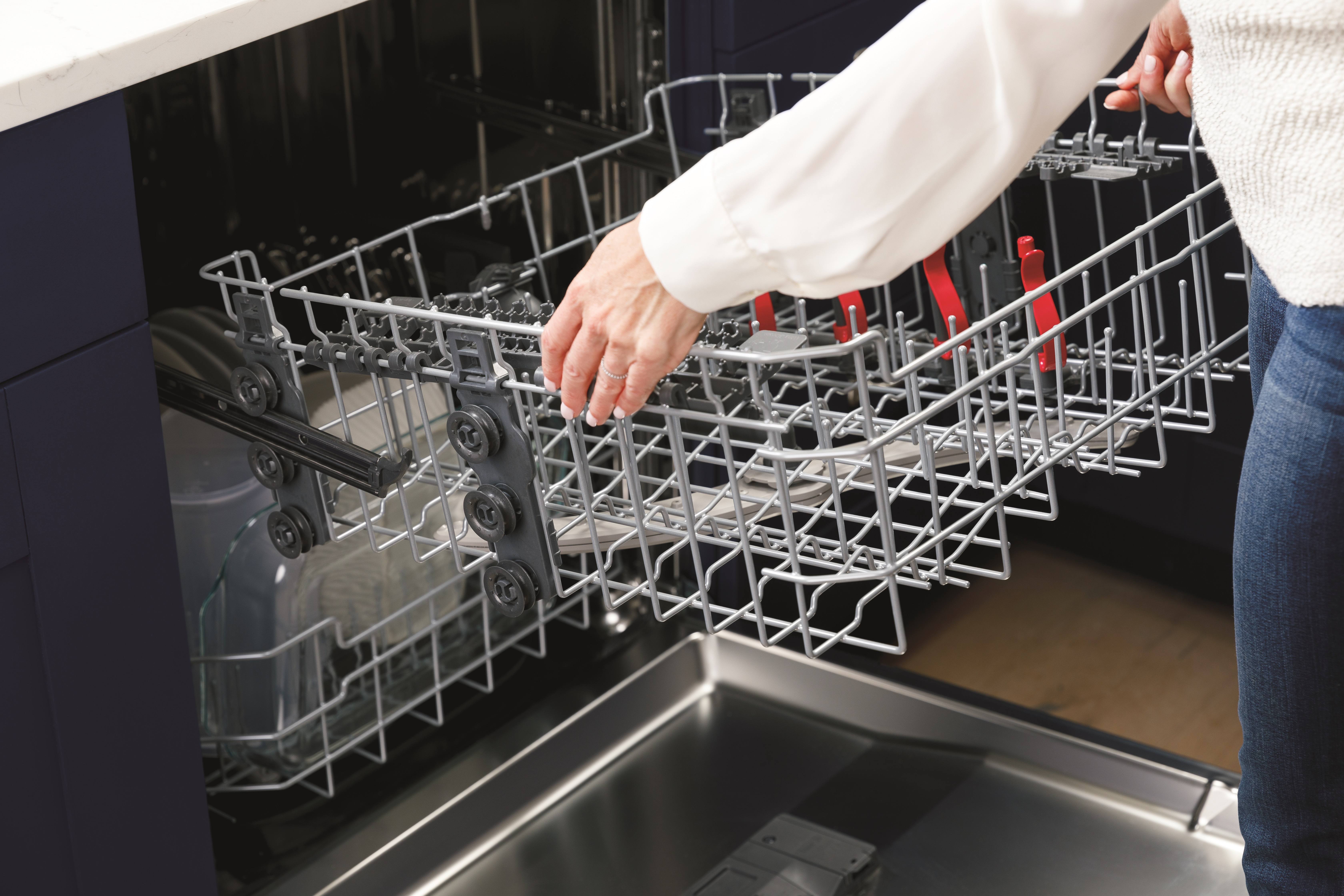 User adjusts GE GDP645SYNFS dishwasher upper rack 
