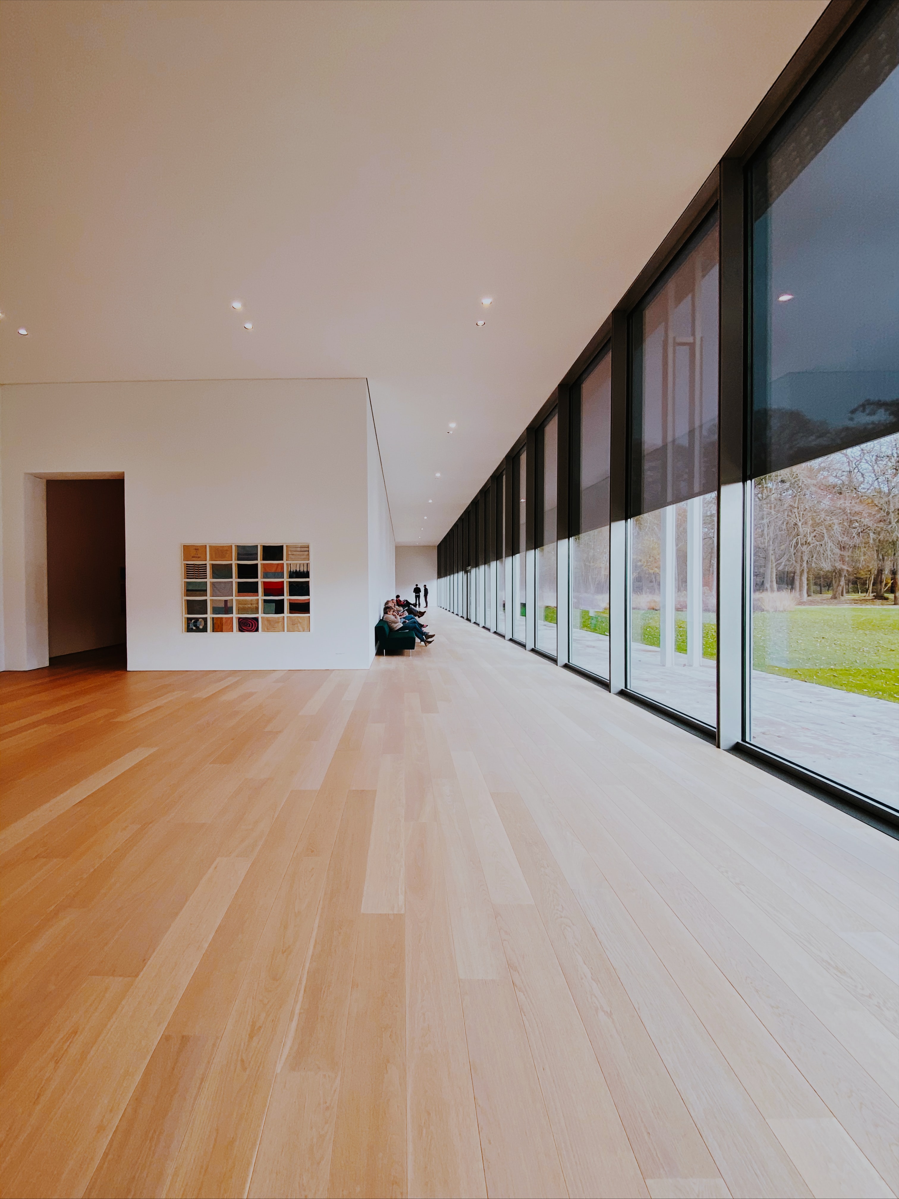 Long open hallway with tall windows and vinyl flooring