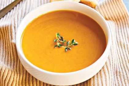 top view of a bowl of autumn soup with a thyme garnish