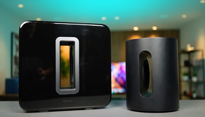 A pair of Sonos speakers on a countertop surrounded by blue lighting.