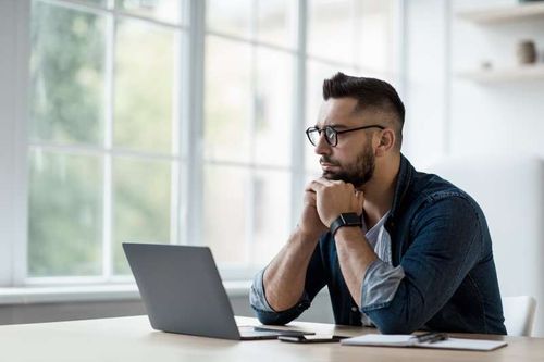 Man Thinking Looking at Laptop