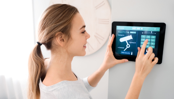 woman looking at home security on tablet