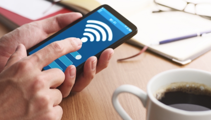 hand hovering phone with WiFi signal