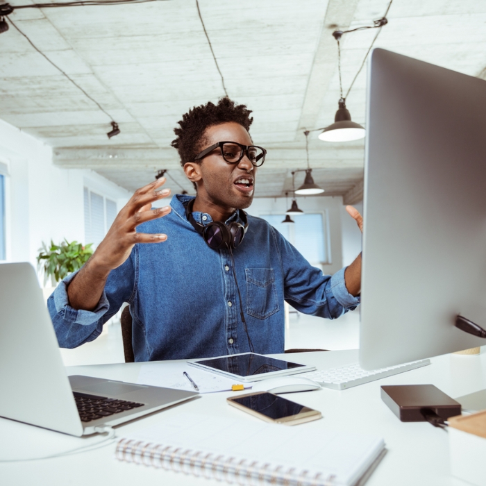 A man is frustrated in front of his desktop computer.