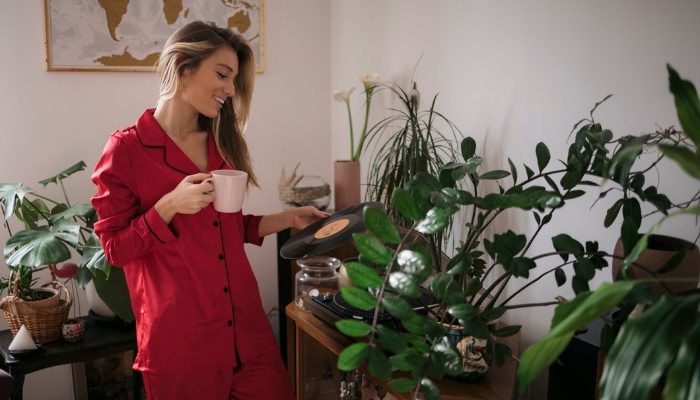 Woman in red pajamas putting a record on