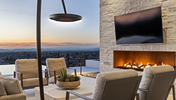 An outdoor patio with a TV, fire place, and other heating sources.
