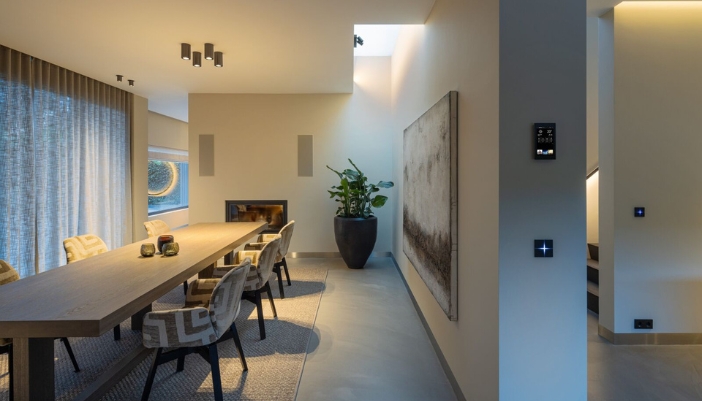 The interior of a modern dining room with smart home elements.