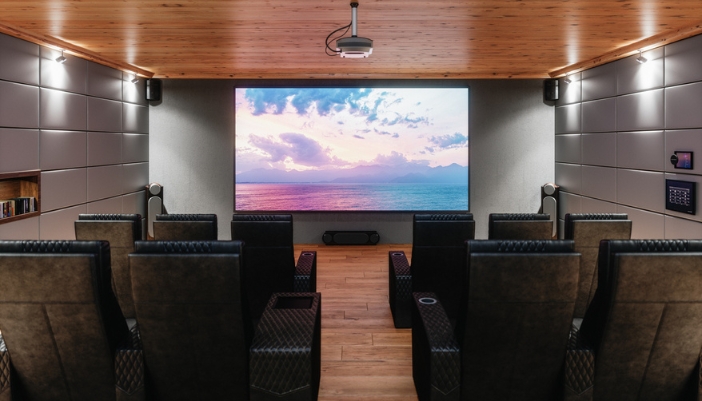 A home theater with black furniture, black walls, and a wooden ceiling.