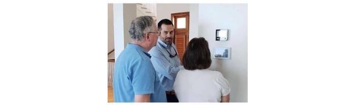security technician educating customers on their new home security control panel
