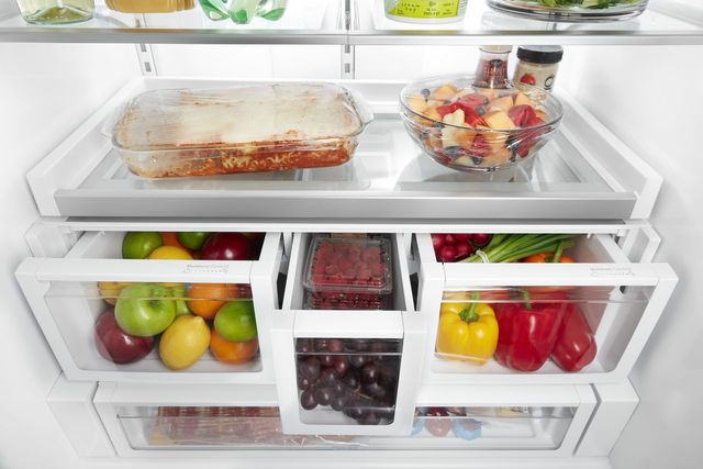 Front view of the inside of an opened and organized refrigerator 