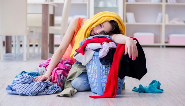 woman stressed and covered in laundry