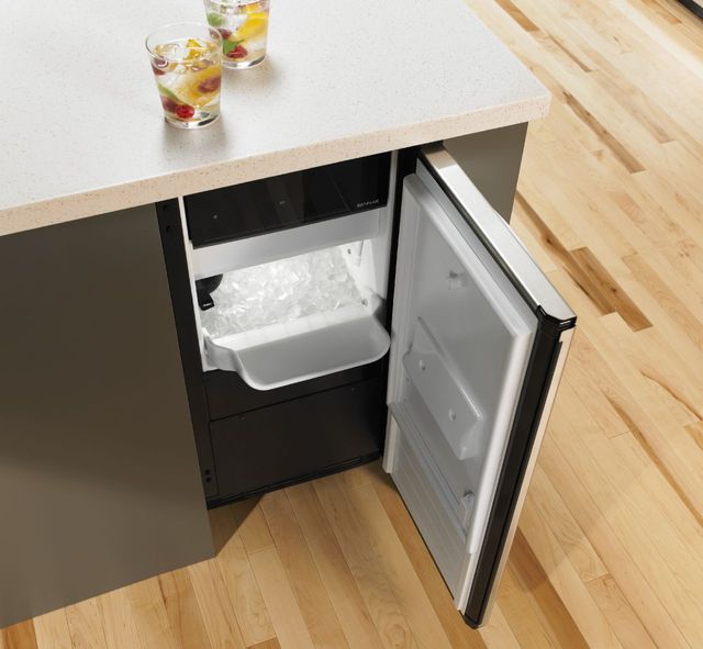 View of an opened JennAir ice maker in a modern kitchen island