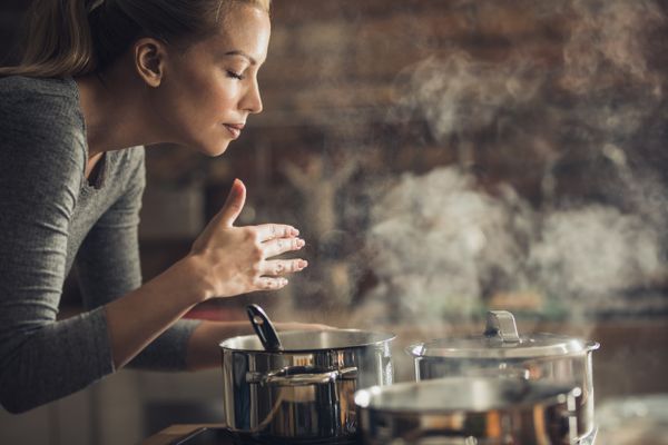 Woman Smelling Cooking Food