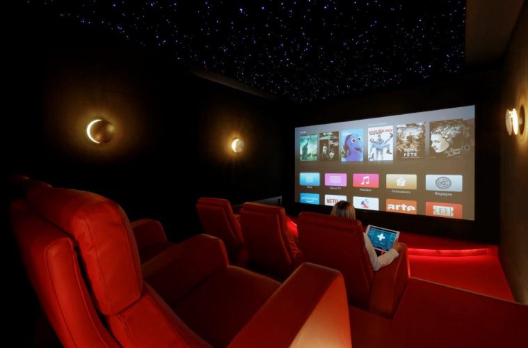A woman chooses what to watch while sitting in a home theater