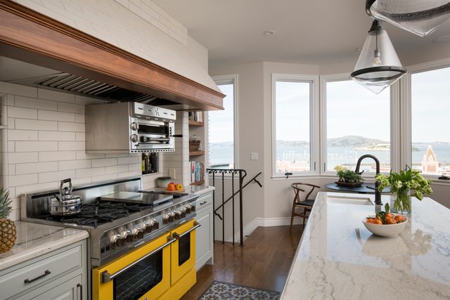 front view of a large open kitchen with an island and a yellow bluestar range
