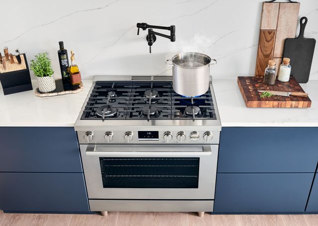 Front standing view of a Bosch 36" gas range with a pot of water boiling on the back right-most burner