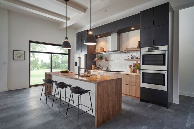 Credit: Wolf Front view of a modern kitchen with a Wolf double wall oven and range