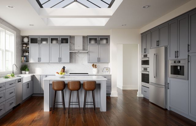 front view of a modern white kitchen with stainless steel bosch appliances, and behind an island is a black bosch induction cooktop