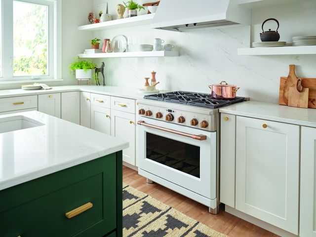 front view of a white cafe range in a modern kitchen with white cabinetry and countertops