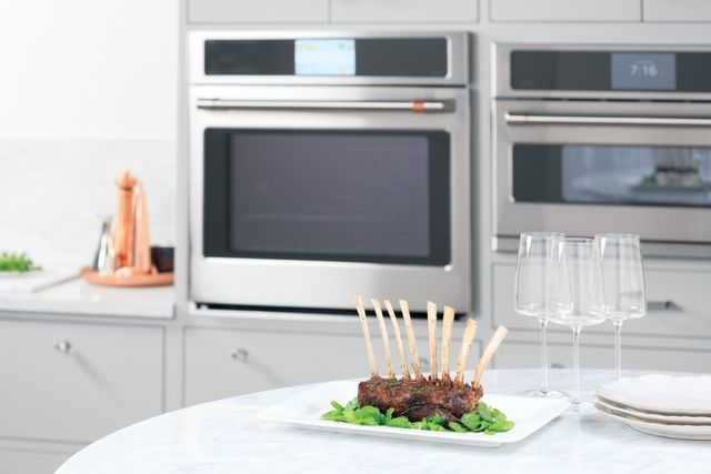 Close view of a roast on a kitchen island with a Cafe wall oven in the background.