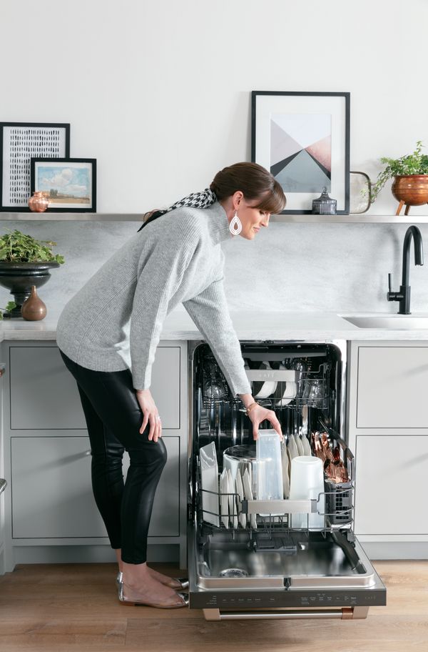 Woman places plastic jug into her dishwasher