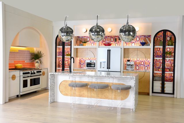 Front view of a modern eclectic kitchen with a white Cafe refrigerator