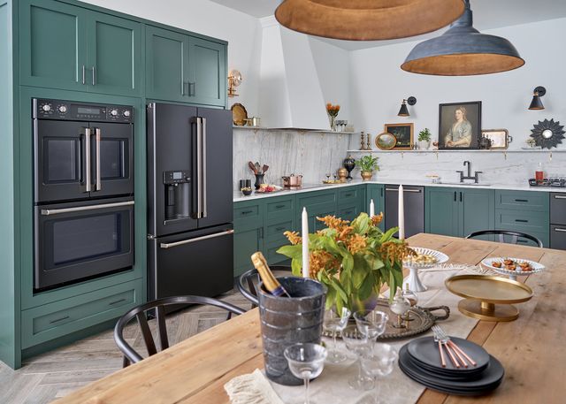 view of a modern kitchen with green cabinets and black cafe appliances, including a french door double wall oven and french door refrigerator