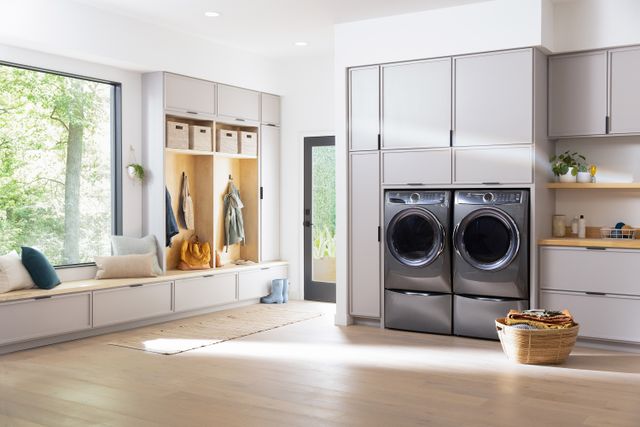 front view of a modern bright laundry room with a grey electrolux washer and dryer