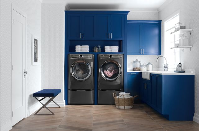 A matching grey Electrolux washer and dryer front load washer pair in a modern blue laundry room 
