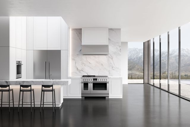front view of a modern white kitchen with a fisher and paykel gas range facing the camera