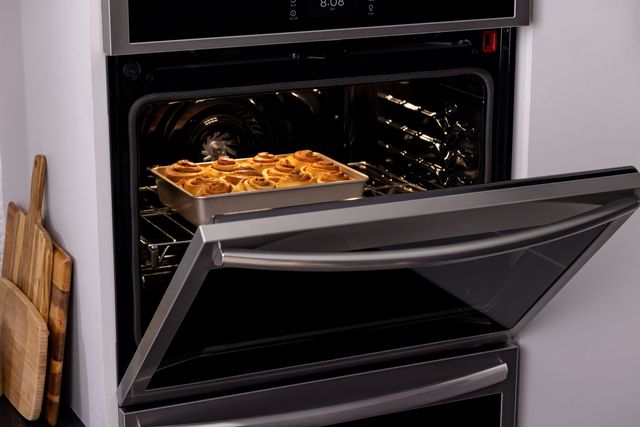 Front view of a pan of cinnamon rolls baking in a Frigidaire oven