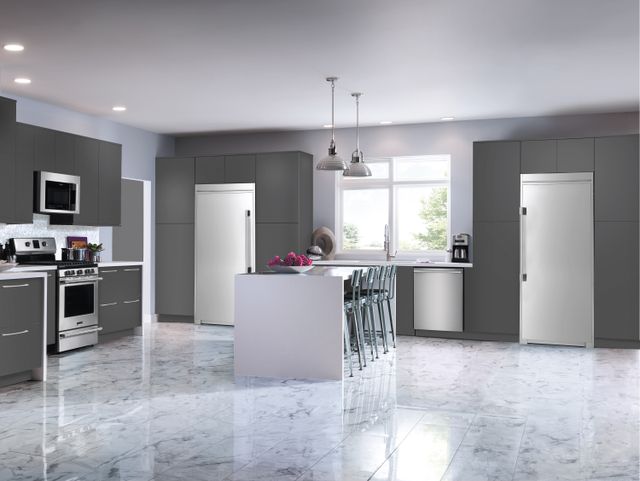 Front view of a modern kitchen with a stainless steel freezerless refrigerator and freezer