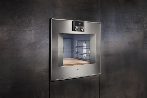 front view of a gaggenau wall oven in a dark grey panel wall