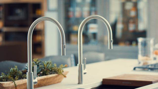 Front close view of two luxury kitchen faucets over a Galley kitchen sink