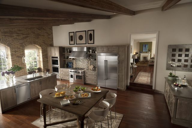 front view of a modern luxurious kitchen with JennAir stainless steel appliances including a range, dishwasher, and refrigerator