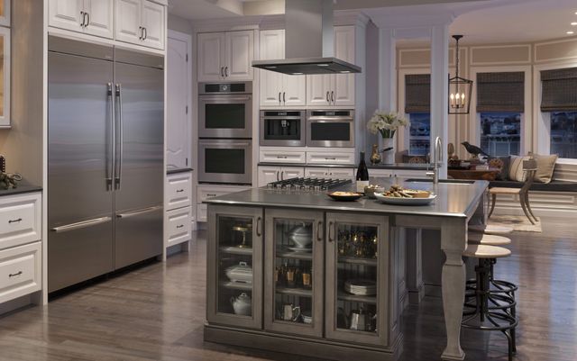 front view of a luxury kitchen with dim lighting and stainless steel JennAir appliances