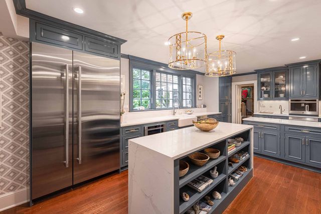Front view of a modern kitchen with a JennAir stainless steel side by side refrigerator