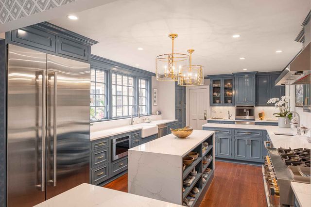 View of a large kitchen with blue cabinetry and stainless steel JennAir appliances.