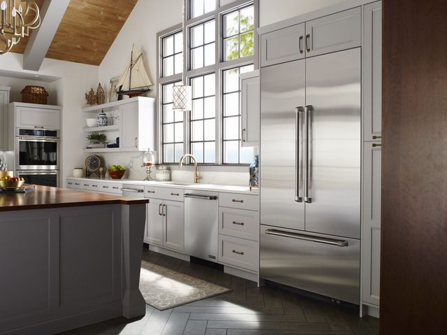 View of a modern galley kitchen with stainless steel JennAir appliances