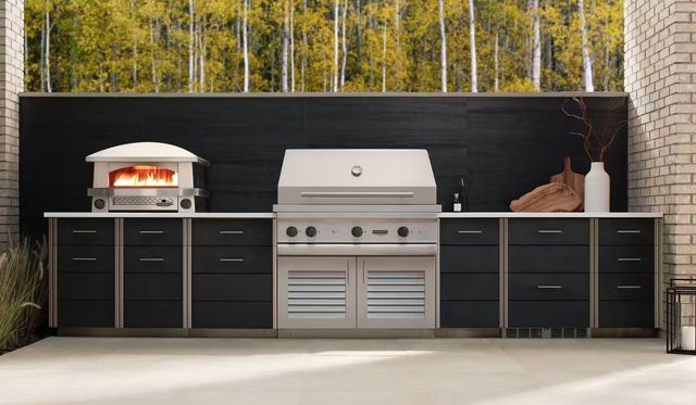 Front view of a modern outdoor cooking space with a stainless steel Kalamazoo built in grill