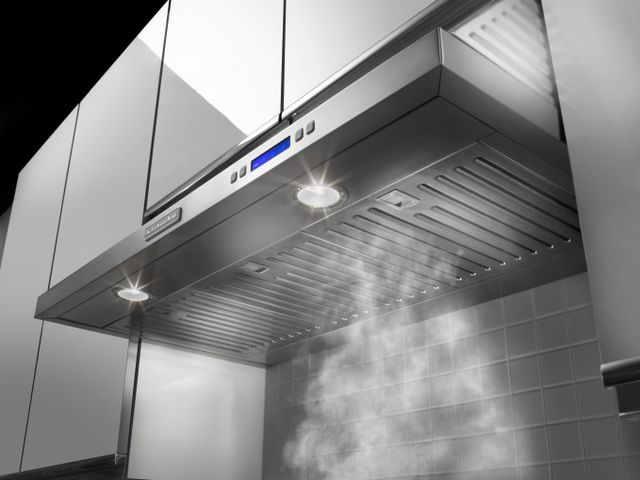Front view of a KitchenAid under cabinet range hood in use