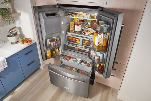 front view of a large opened kitchenaid french door refrigerator that is full