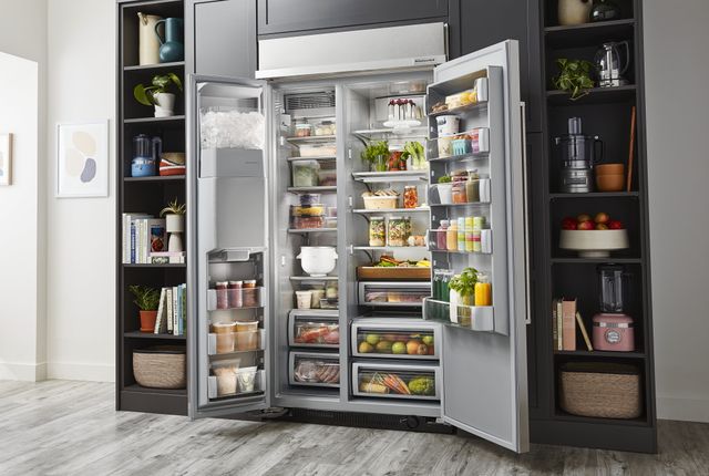 front view of a large opened kitchenaid side-by-side refrigerator that is full