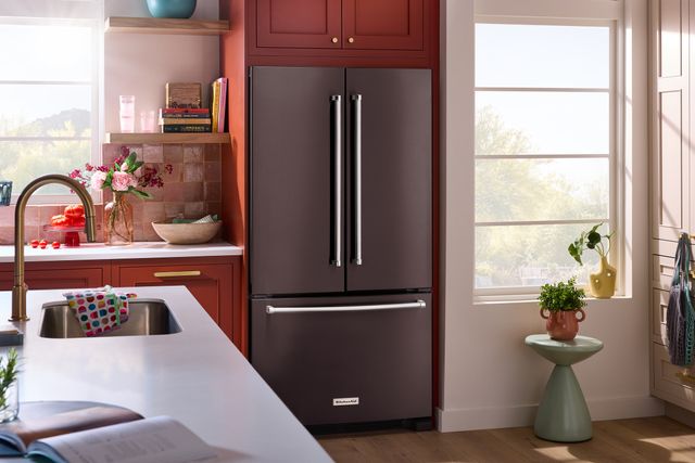 front view of a modern kitchen with orange cabinetry and a black stainless steel refrigerator from kitchenaid